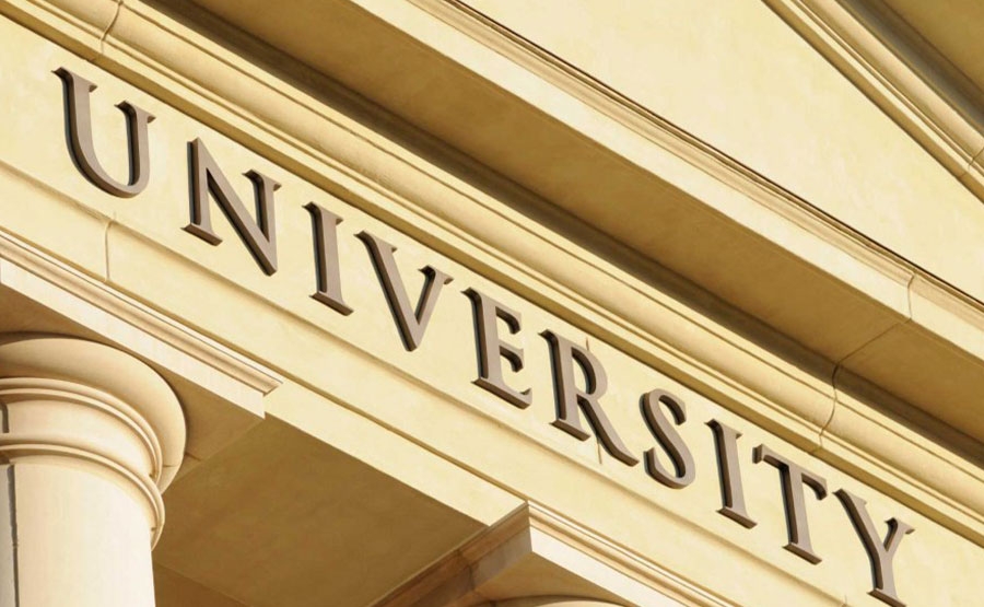 Close-up of a classical-style university building facade, showing large stone columns and the word UNIVERSITY in bold letters above the entrance.