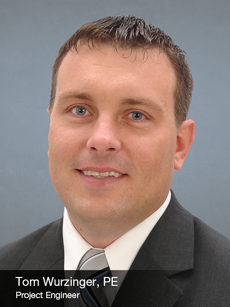 A man in a suit and tie smiles at the camera in a professional headshot. Text at the bottom reads: Tom Wurzinger, PE, Project Engineer. The background is plain and gray.