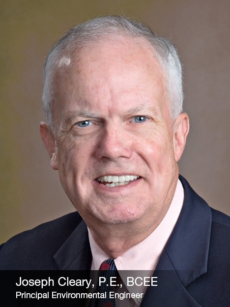 e53f03b4d09ef1ab6bce158b6e851ce9 A middle-aged man with short gray hair, wearing a dark suit jacket, light pink shirt, and tie, smiling at the camera. Text at the bottom reads: Joseph Cleary, P.E., BCEE, Principal Environmental Engineer.
