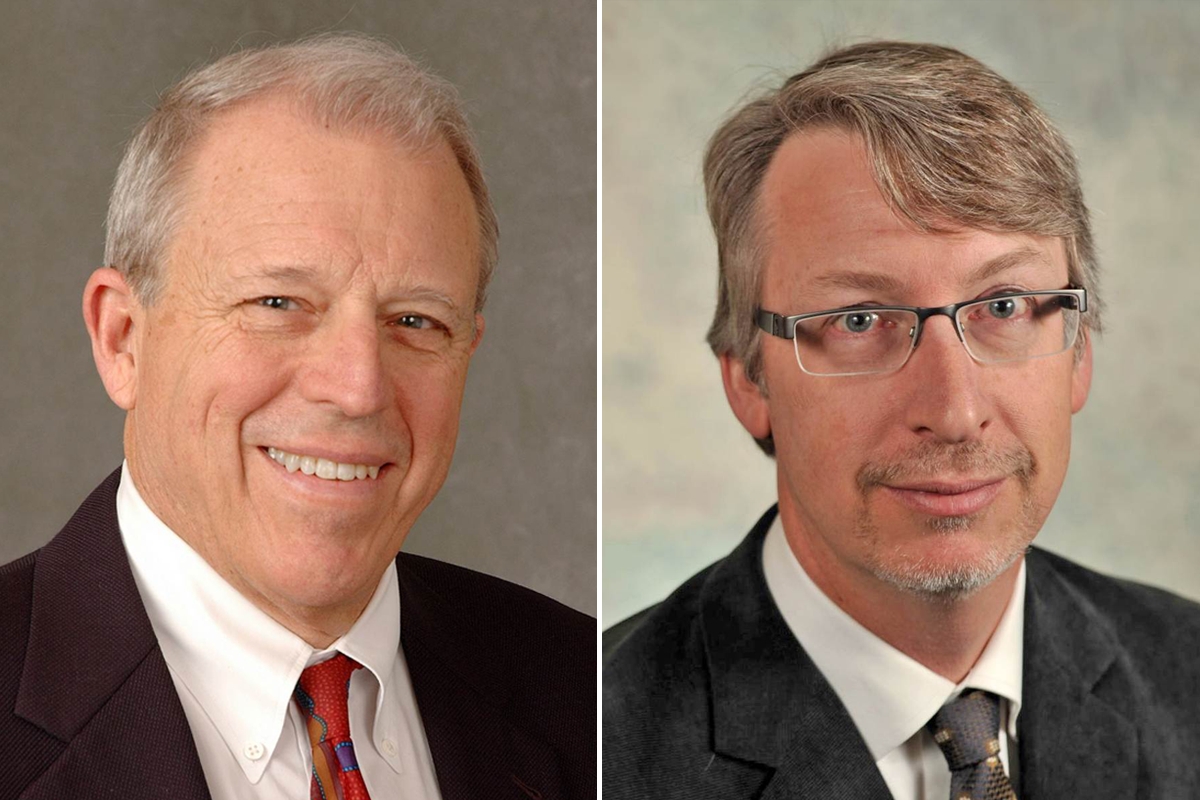 Side-by-side portraits of two men in suits; the man on the left has gray hair and is smiling, while the man on the right has light brown hair, glasses, and a neutral expression.