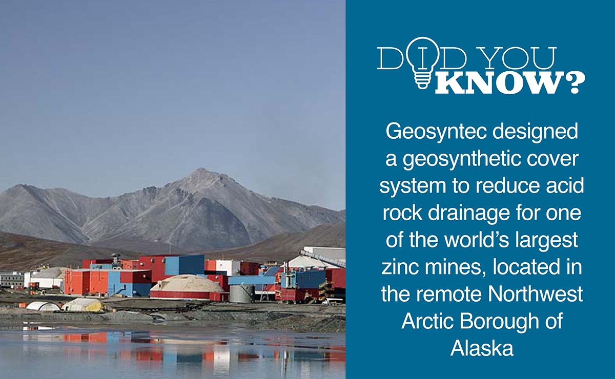 A cluster of industrial buildings with colorful exteriors sits at the base of rocky mountains in Alaska. A fact on the right explains a geosynthetic cover system designed to reduce acid rock drainage at a large zinc mine.