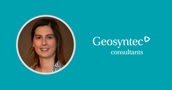 A woman with long brown hair smiles at the camera, set against a teal background. Beside her, white text reads Geosyntec consultants with a triangular logo.